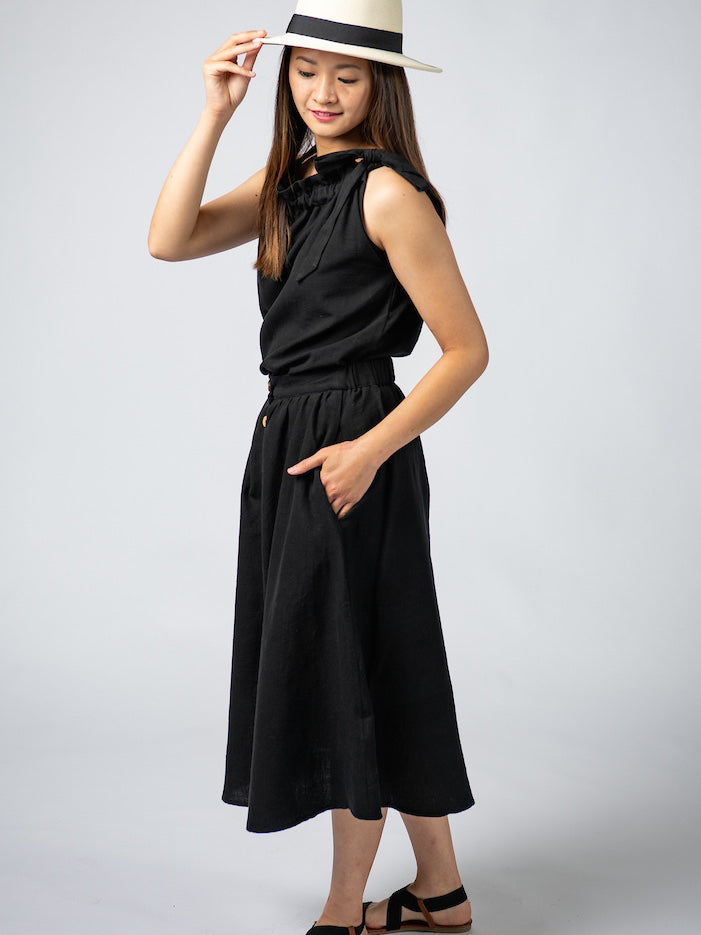 Swahlee creates a handmade capsule wardrobe of clothing essentials made in India using sustainable production and natural fabrics. The Button Midi Skirt in Black.