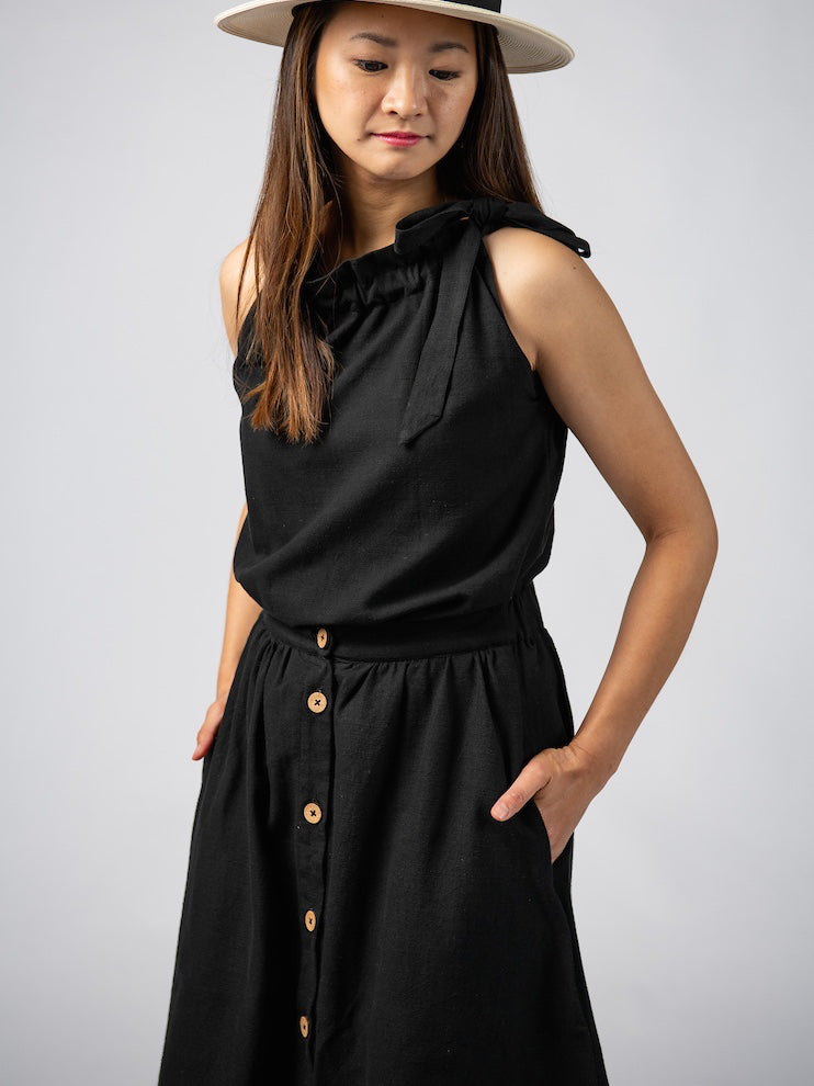 Swahlee creates a handmade capsule wardrobe of clothing essentials made in India using sustainable production and natural fabrics. The Button Midi Skirt in Black.