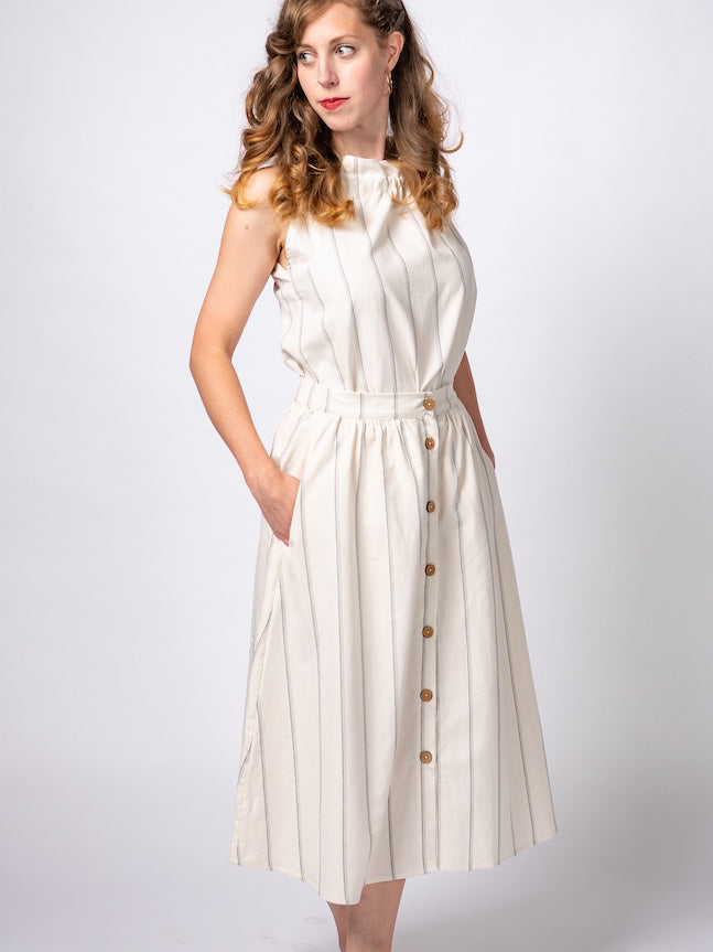Swahlee creates a handmade capsule wardrobe of clothing essentials made in India using sustainable production and natural fabrics. The Button Midi Skirt in Natural with Sage Stripes..
