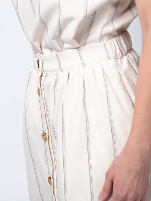 Swahlee creates a handmade capsule wardrobe of clothing essentials made in India using sustainable production and natural fabrics. The Button Midi Skirt in Natural with Sage Stripes..