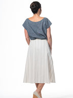 Swahlee creates a handmade capsule wardrobe of clothing essentials made in India using sustainable production and natural fabrics. The Button Midi Skirt in Natural with Sage Stripes.