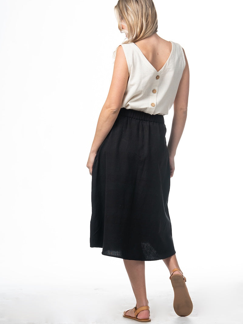 Swahlee creates a handmade capsule wardrobe of clothing essentials made in India using sustainable production and natural fabrics. The Button Midi Skirt in Black.